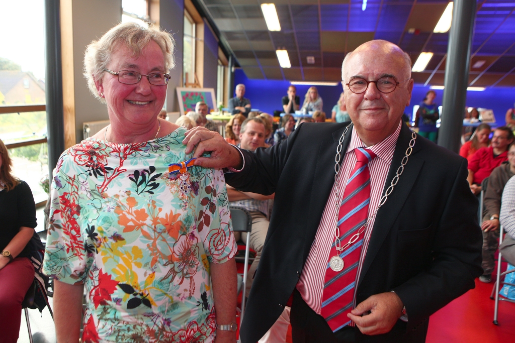 Mevrouw Eline Meijer met de onderscheiding die ze door de burgemeester kreeg opgespeld.