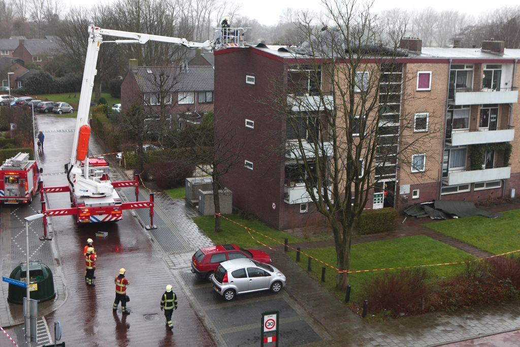 De brandweer moest met de hoogwerker het losgeraakte stuk dak weghalen.
