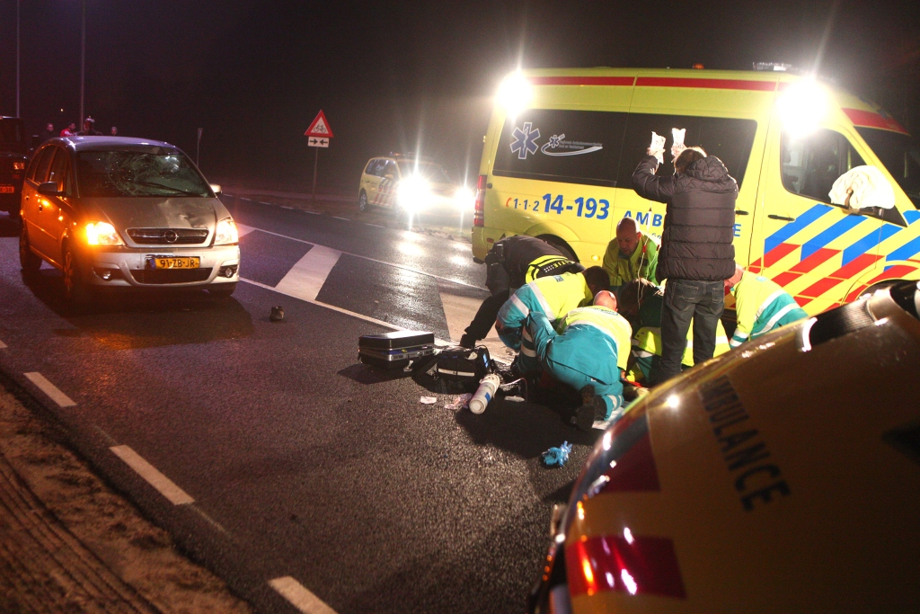 Het ambulancepersoneel behandelt de aangereden fietser op de Randweg.