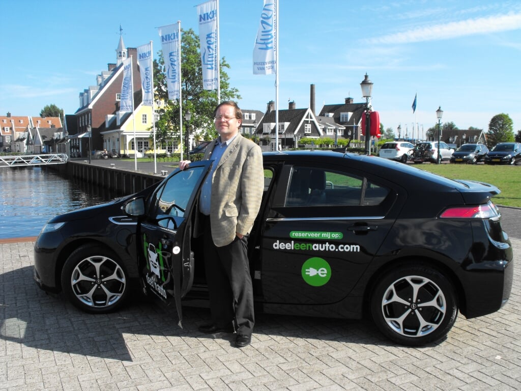 Rob Bource, hier met een deelauto op de foto, heeft uit passie voor duurzaamheid en vervoer E-motion georganiseerd.