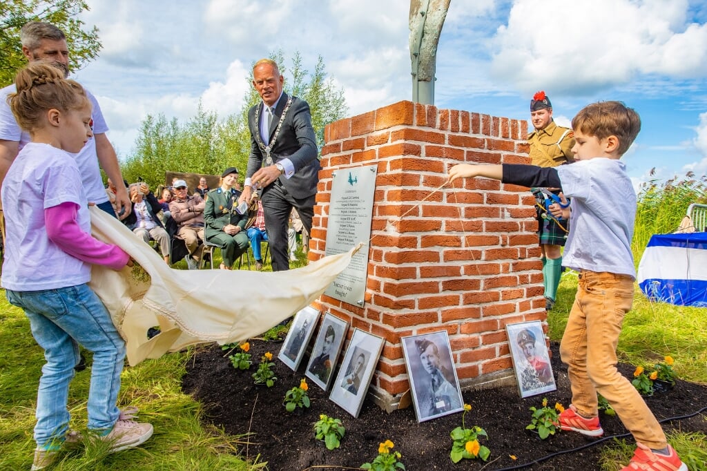 Burgemeester Han ter Heegde en de kinderen van David van Coolwijk onthullen het monument.