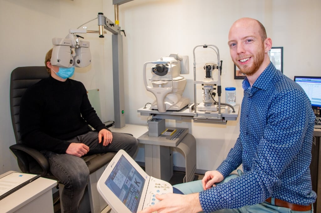 Optometrist Ruben van der Waal onderzoekt de ogen van een klant.