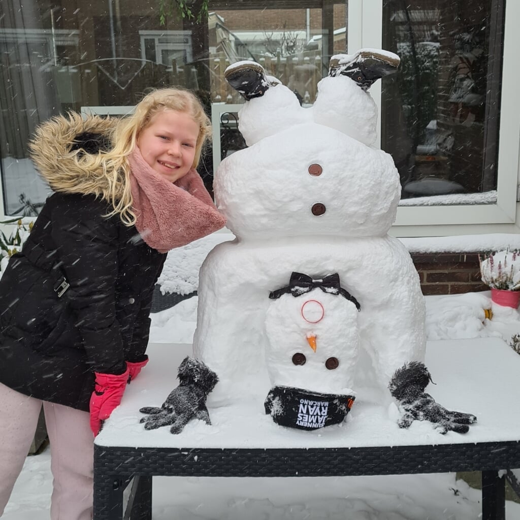Leonies (12) sneeuwpop maakt een handstand.