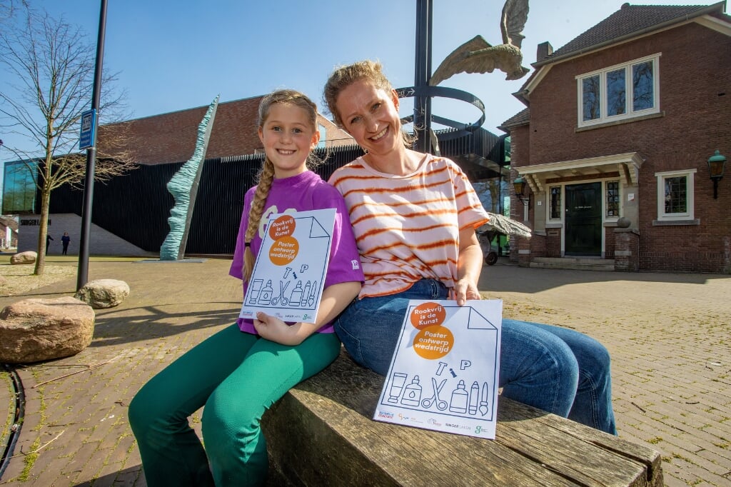 Dochter Jasmijn mocht van moeder Dineke Soer het werkboekje 'Rookvrij is de Kunst' alvast uitproberen.