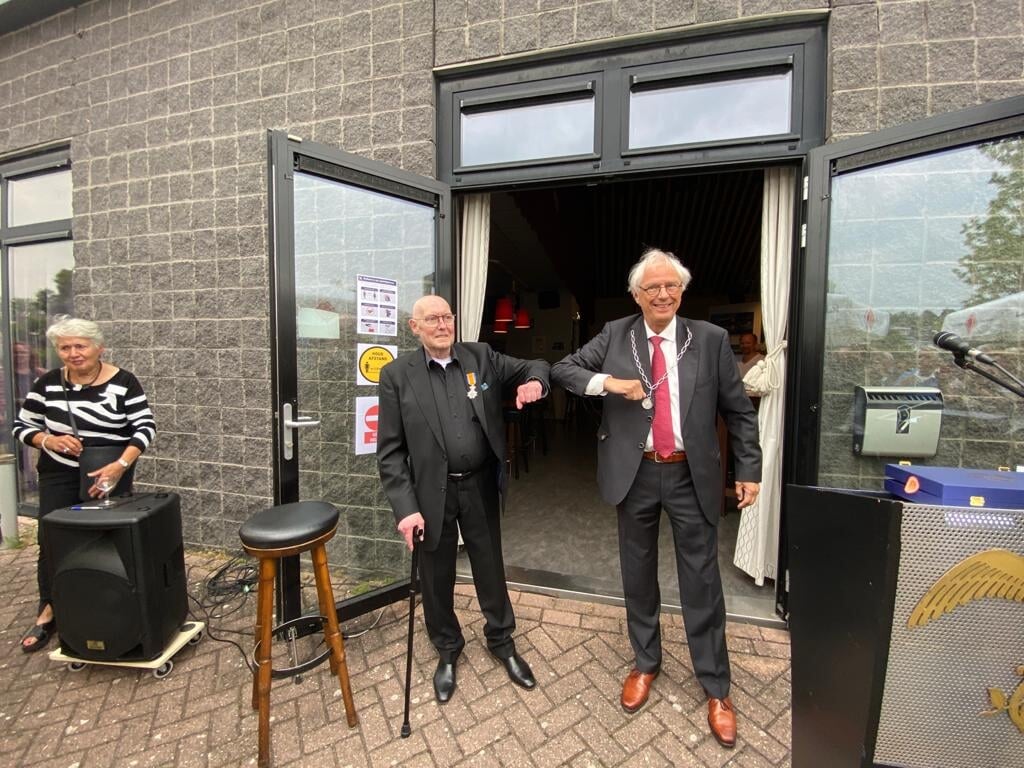Wim Versteegen (links) is blij met zijn Koninklijke onderscheiding die hij kreeg uit handen van burgemeester Bas Jan van Bochove.