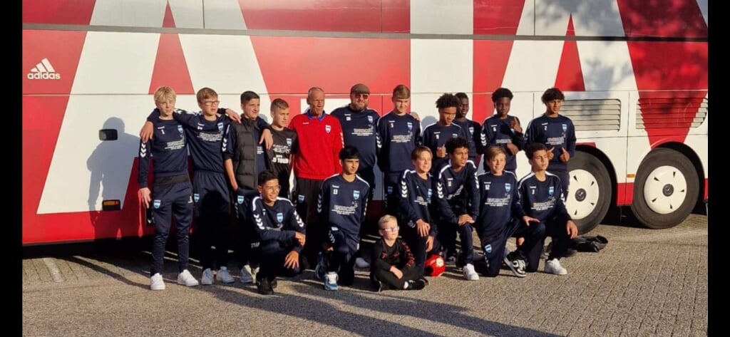 Het team poseert voor de Ajax bus