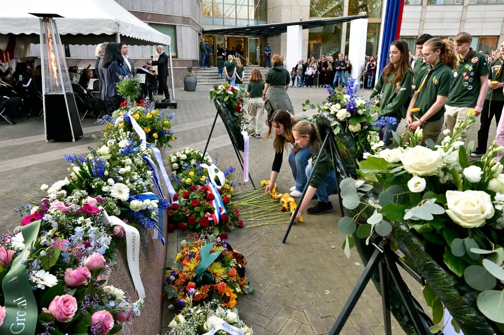 Leden van Scouting Diemen leggen bloemen bij het monument.