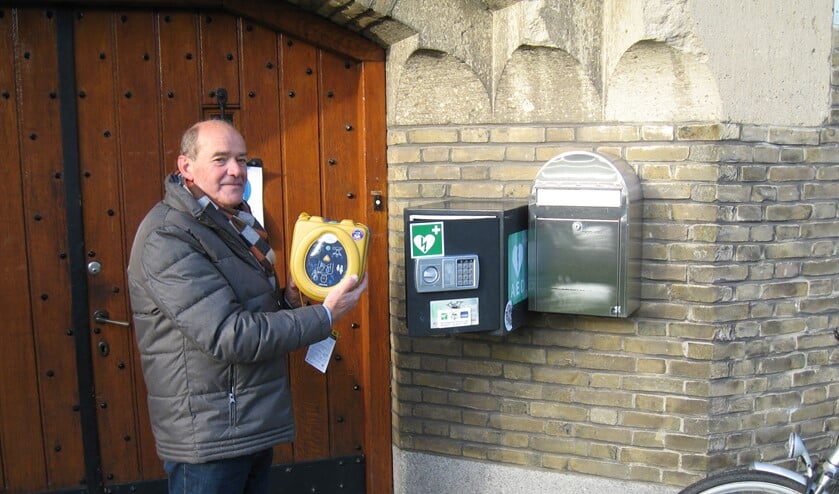 <p>Voorzitter van de KBO Geldrop-Mierlo Hans Gruintjes plaatst de nieuwe AED op het Sint Jozefplein.</p>