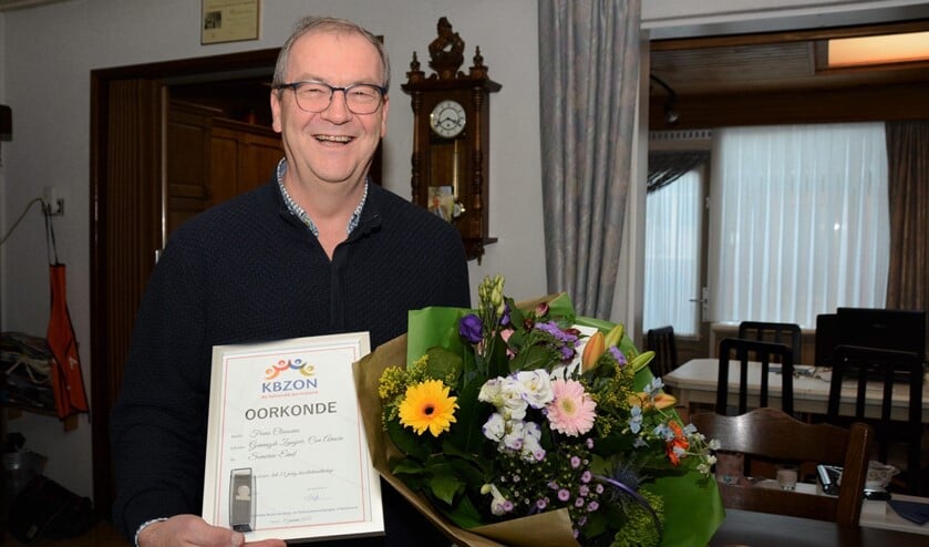 <p>Frans Claessens met een oorkonde en bloemen. (Foto: Nannie van Hoof)</p>