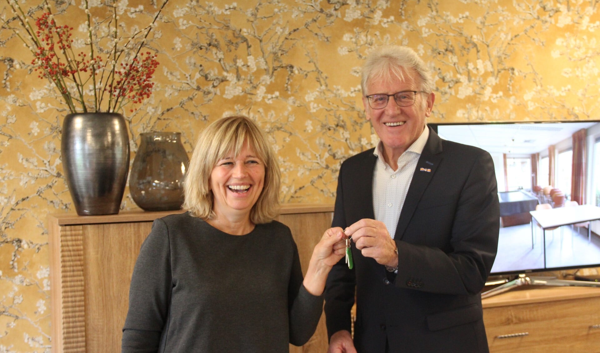 Voorzitter van het Dorpsoverleg Annette Wilde (l) overhandigt Martien Kusters de sleutel van Henricushof.