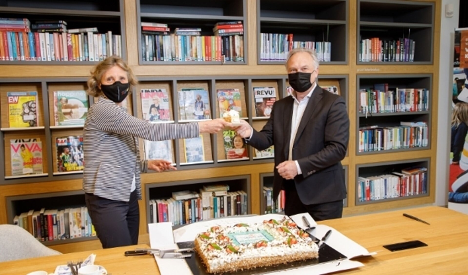 Wethouder Liesbeth Sjouw en Albert Kivits, directeur van de Bibliotheek Eindhoven, bezegelen de nieuwe overeenkomst. 