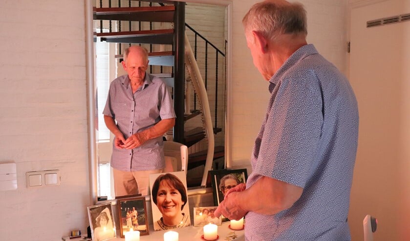 <p>Jacques Mulders bij de foto's van zijn overleden echtgenote in de hal van zijn huis. </p>