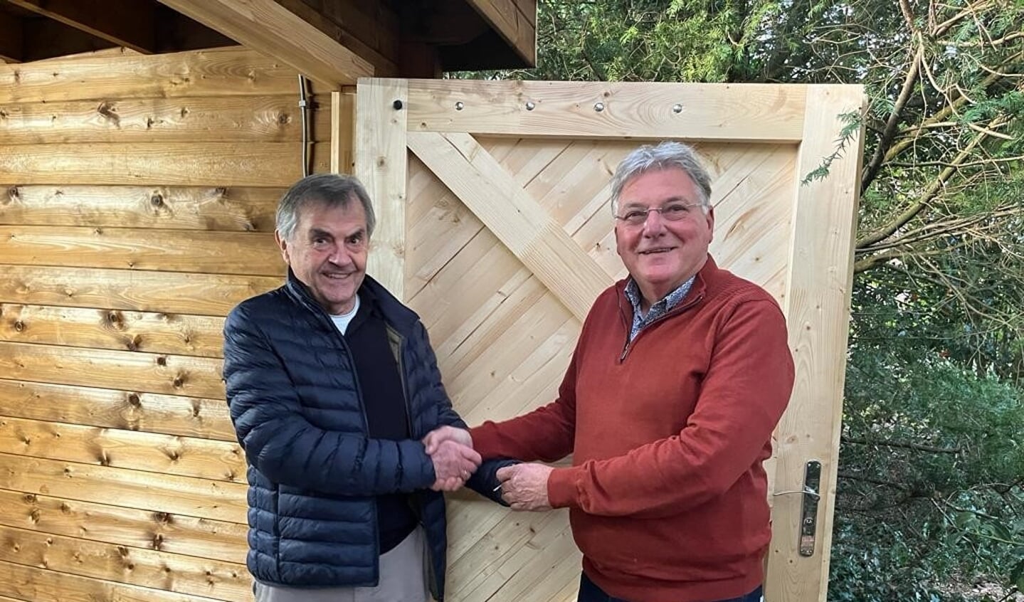 Piet van Dalen (AD-kerk) met rechts Tony Liebregts van de Voedselbank bij het overhandigen van de sleutels voor de nieuwe berging.