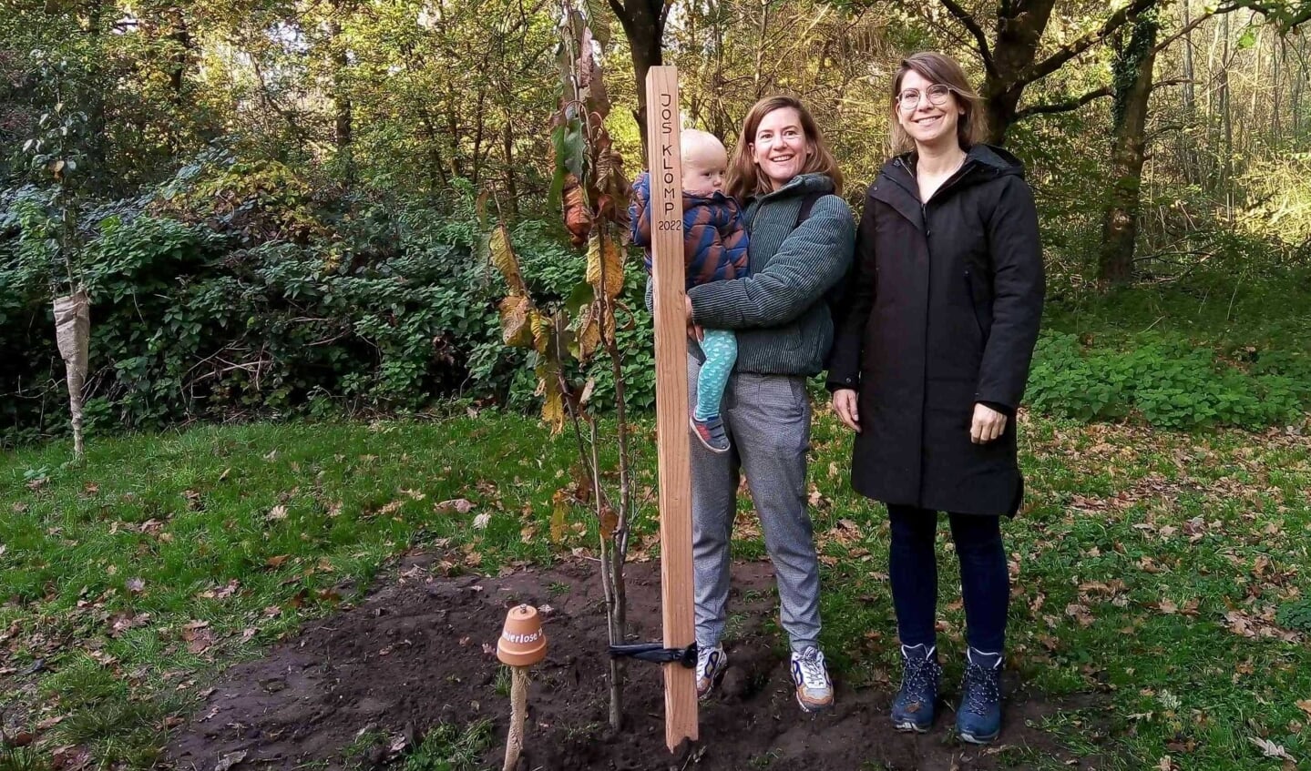 Dochters Floortje (links) en Barbara bij de jgeplante kersenboom als herinnering aan hun vader Jos.