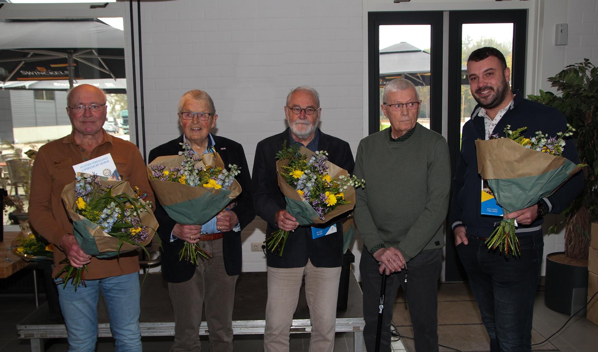  De jubilarissen van links naar rechts: Mart van Dam, Wim van Goch, Harrie van den Elsen, Edy Lenssen. Uiterst recht staat Rob van Berlo namens oprichter Tonny van Berlo. Op de foto ontbreken Johnny Vrijnsen en Cor Madou.