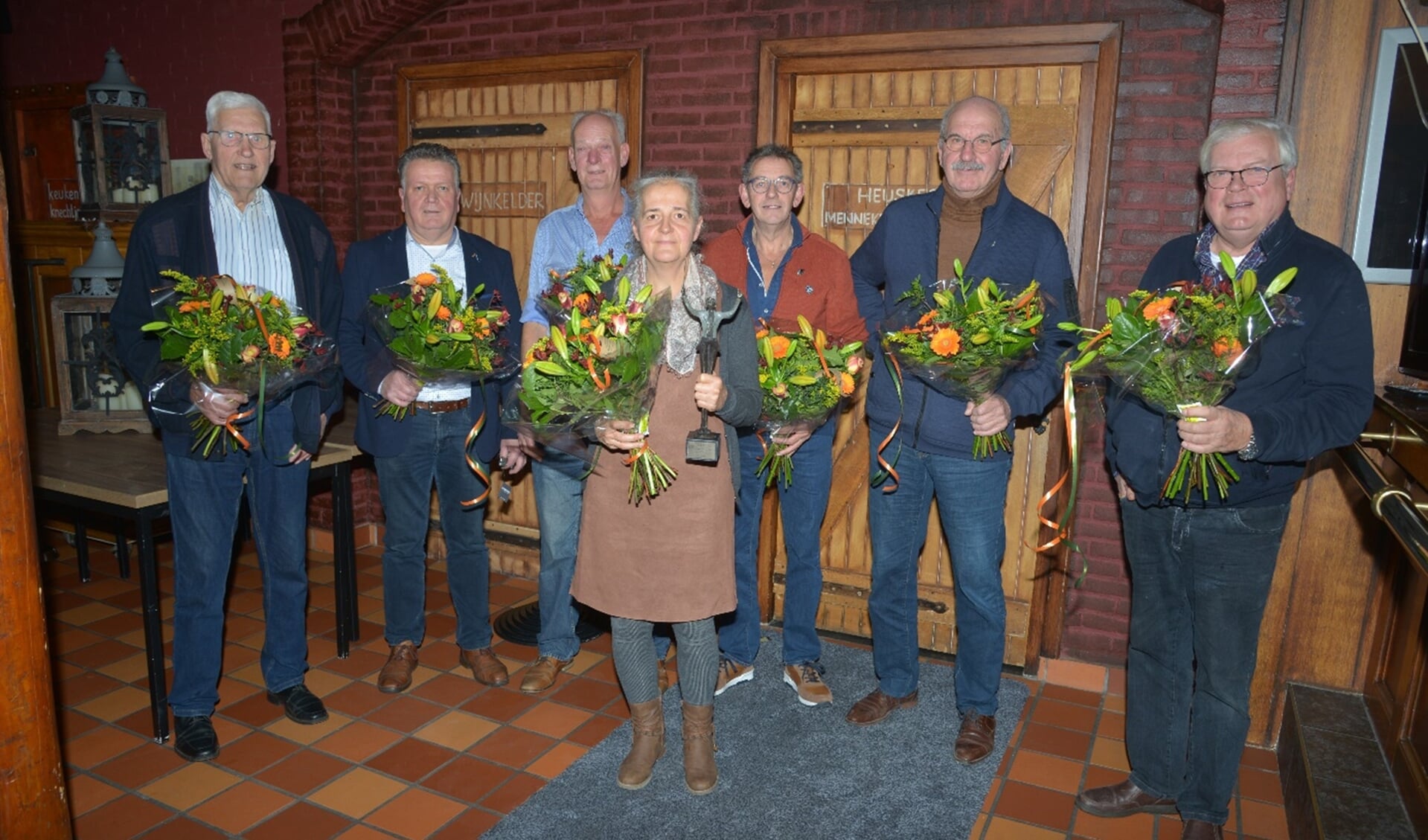 Mannenkoor A Capella heeft zaterdag tijdens hun Ceciliafeest enkele jubilarissen gehuldigd. In het midden dirigente Marion van Eijk.