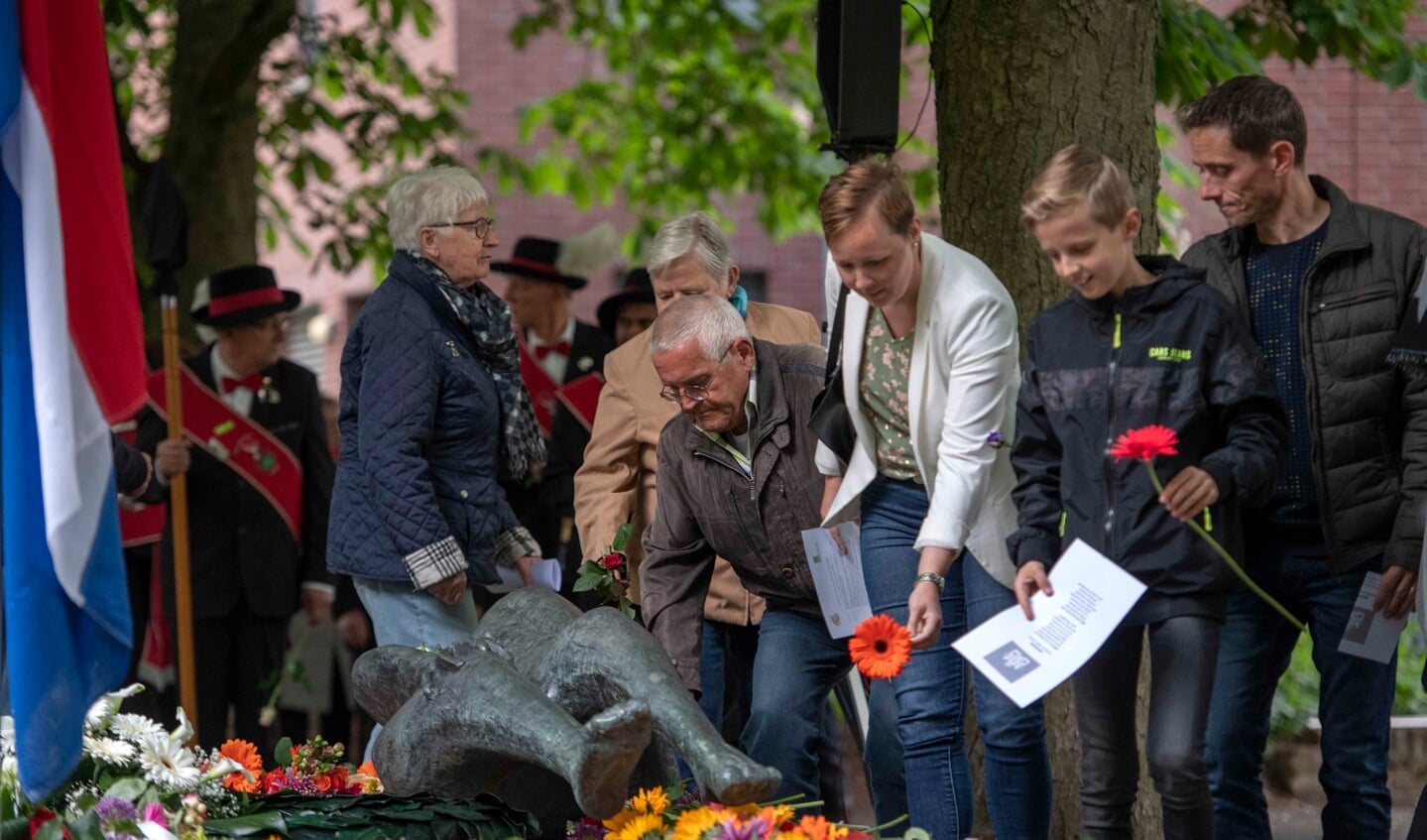 Bezoekers van de Dodenherdenking leggen bloemen op het oorlogsmonument in het Moussaultpark in Asten. (Foto: Hein van Bakel)