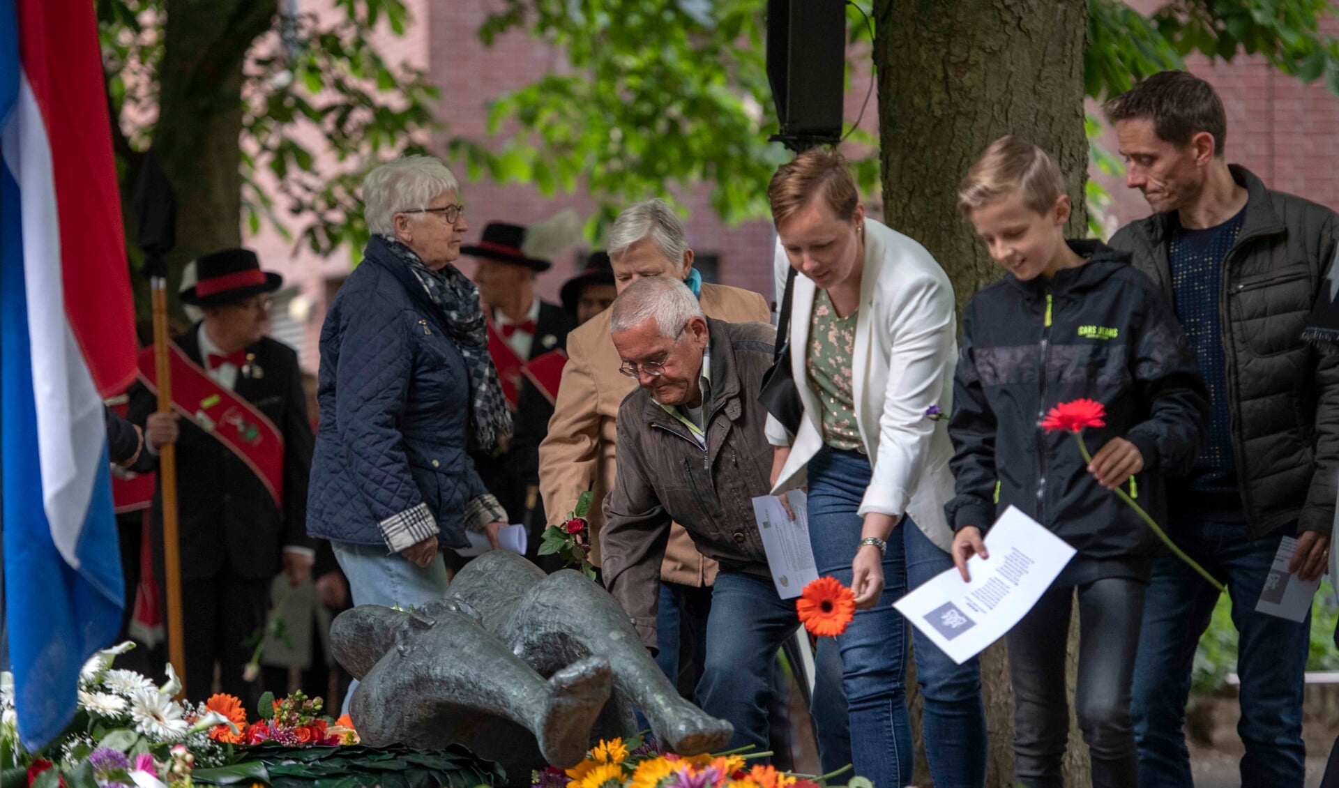 Bezoekers van de Dodenherdenking leggen bloemen op het oorlogsmonument in het Moussaultpark in Asten. (Foto: Hein van Bakel)
