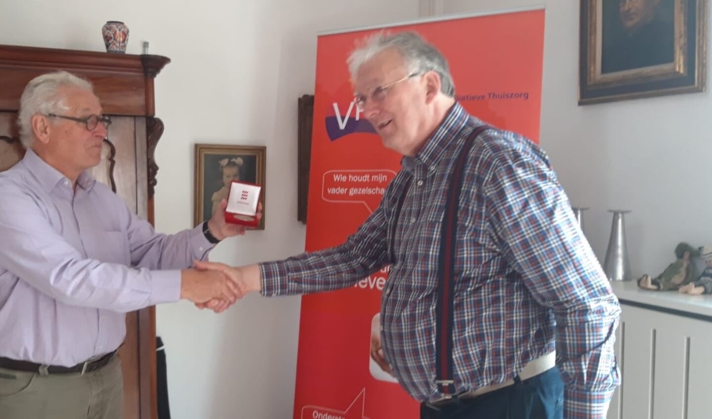 Marc Slijpen (l) overhandigd René van Kaam de vrijwilligerspenning van de gemeente Eindhoven.