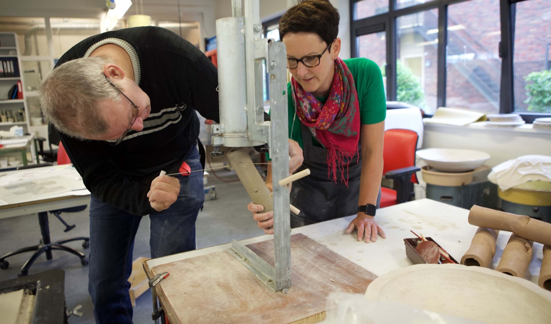 Cindy Heldens met een deelnemer van Kempro in het atelier bezig met het maken van een buis.
