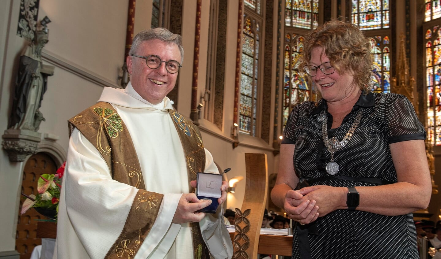 Pastoor Paul Janssen ontving bij zijn afscheid de Legpenning uit handen van burgemeester Greet Buter. 