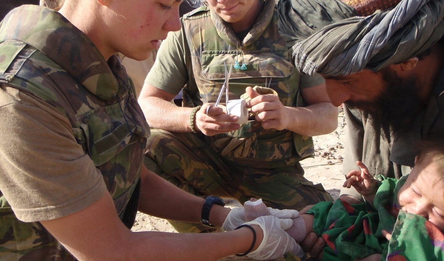 Loes van den Boomen behandelt een kind aan diens verwondingen tijdens een van haar missies in Afghanistan.