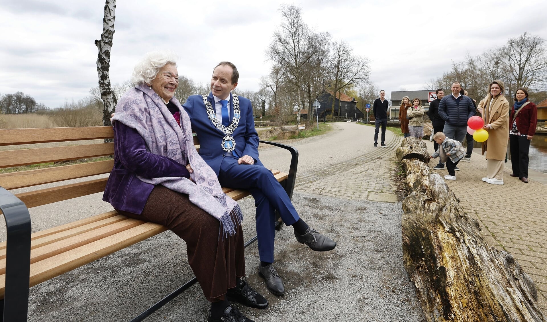 De 100-jarige mevrouw Riet van der Avort-Huijben op 'haar' bankje samen met burgemeester Ederveen.