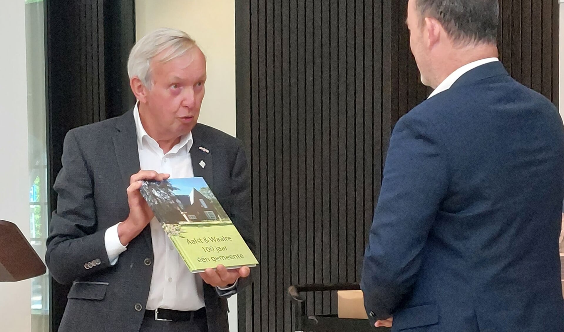 Lambert Jansen overhandigt het eerste exemplaar van het boek aan wethouder Kees Vortman.