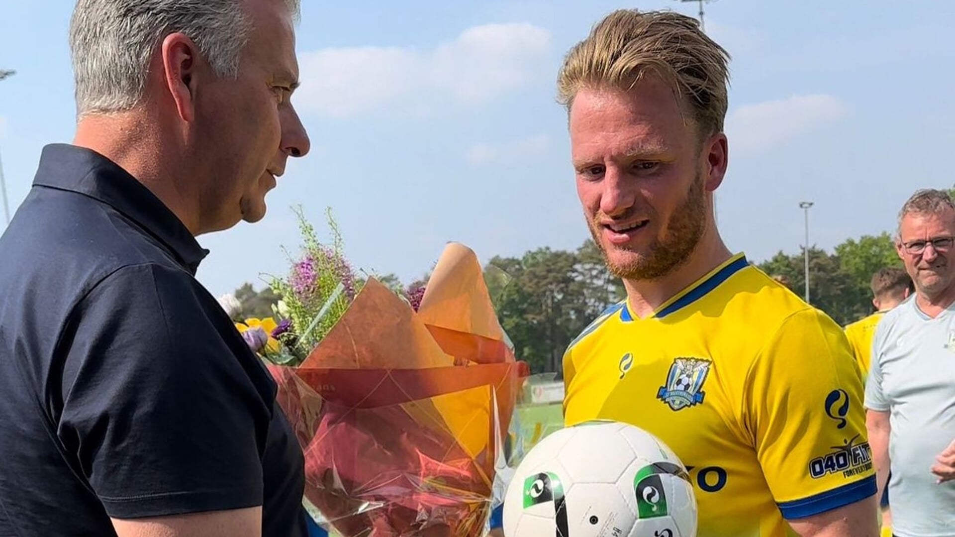 Voorzitter Ruud van Dijk overhandigt een bos bloemen aan Jordi van Meurs die zijn laatste thuiswedstrijd in het 1e elftal speelde