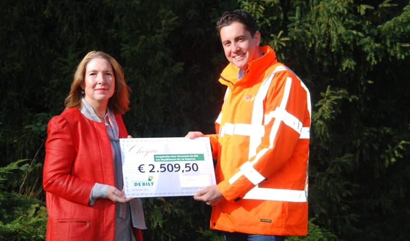 ?Jolanda van Hulst overhandigt de cheque aan Niels van Bladeren.