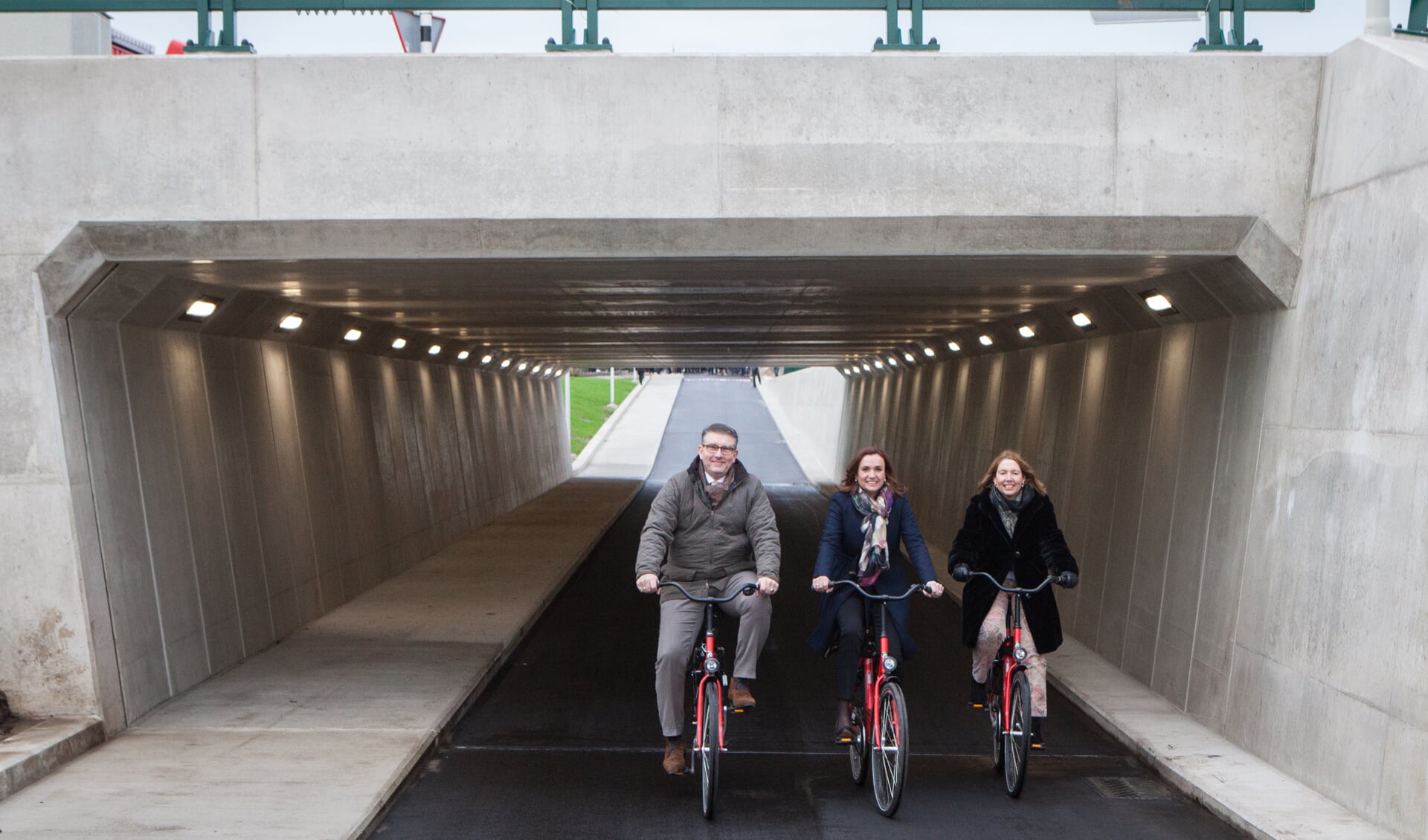 Wethouder Roy Luca van Zeist, gedeputeerde Jacqueline Verbeek-Nijhof en wethouder Jolanda van Hulst nemen de fietstunnel officieel in gebruik.