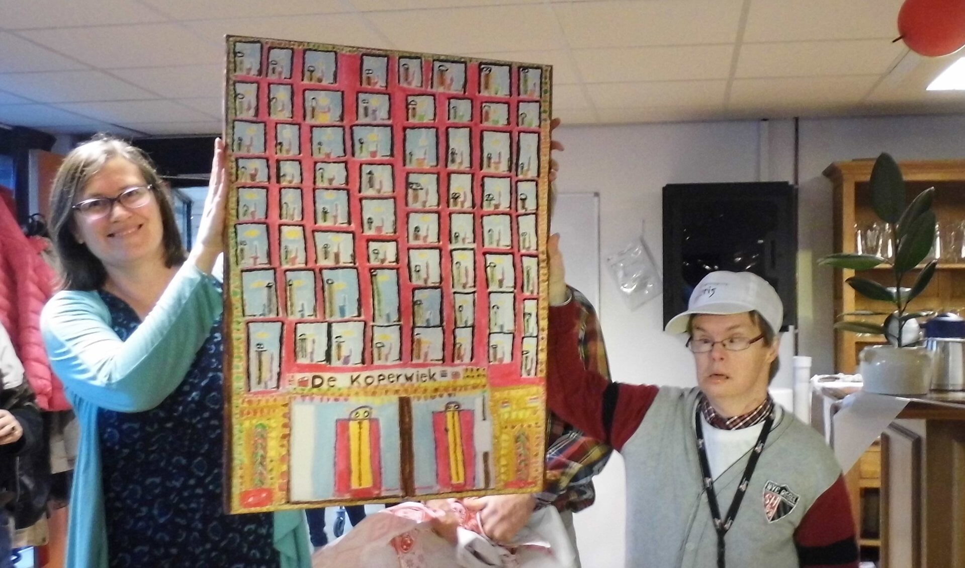 Kunstenaar Luuk overhandigt een zelfgeschilderd schilderij aan clustermanager Heleen van de Pijpekamp.