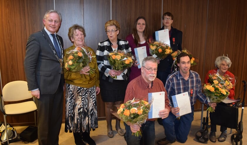 De onderscheiden vrijwilligers naast burgemeester Arjen Gerritsen.