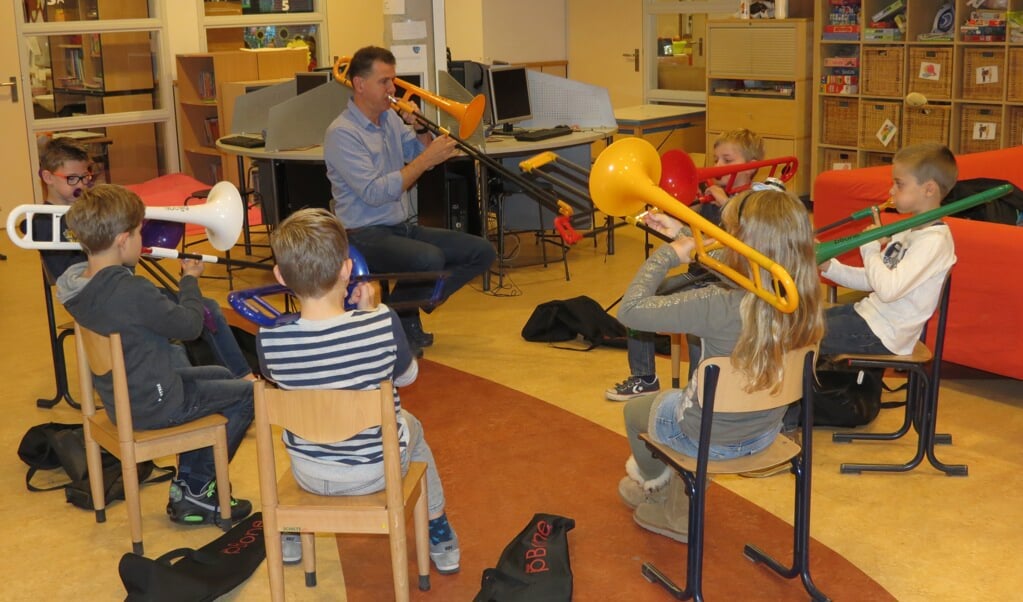 Trombonedocent Martien de Kam geeft les aan leerlingen van groep 5 van de Julianaschool.