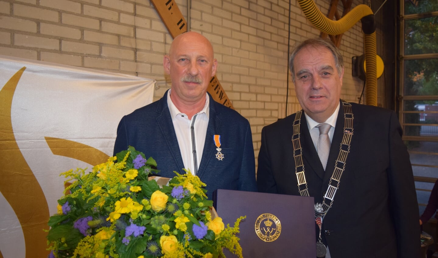 Vrijwillige brandweerman Frans van den Berg uit Bilthoven krijgt vanwege zijn verdiensten door wnd. burgemeester Bas Verkerk de versierselen, behorend bij zijn benoeming tot  Lid in de Orde van Oranje-Nassau, opgespeld.