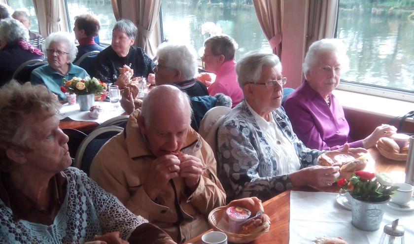 Zonnebloemgasten genieten aan boord van de lunch.