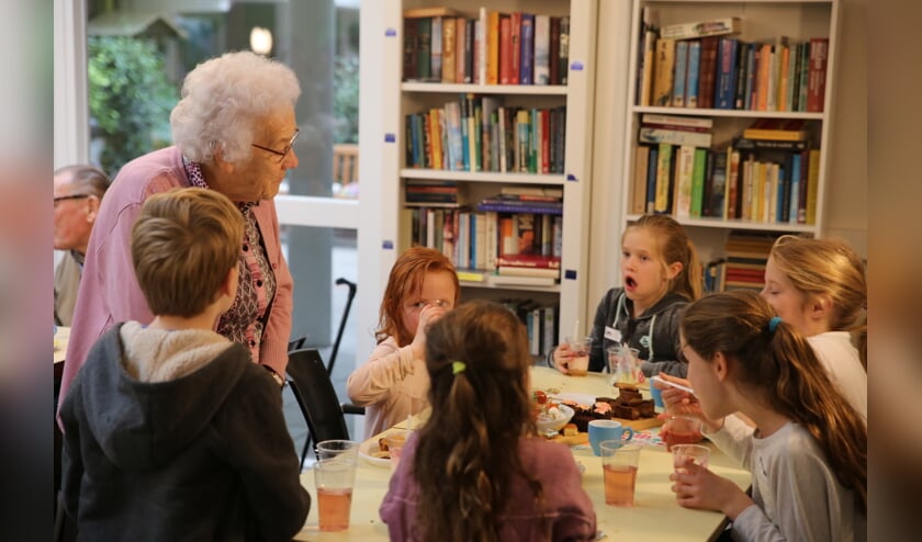 De bakkers smikkelen mee tijdens de high tea voor ouderen.
