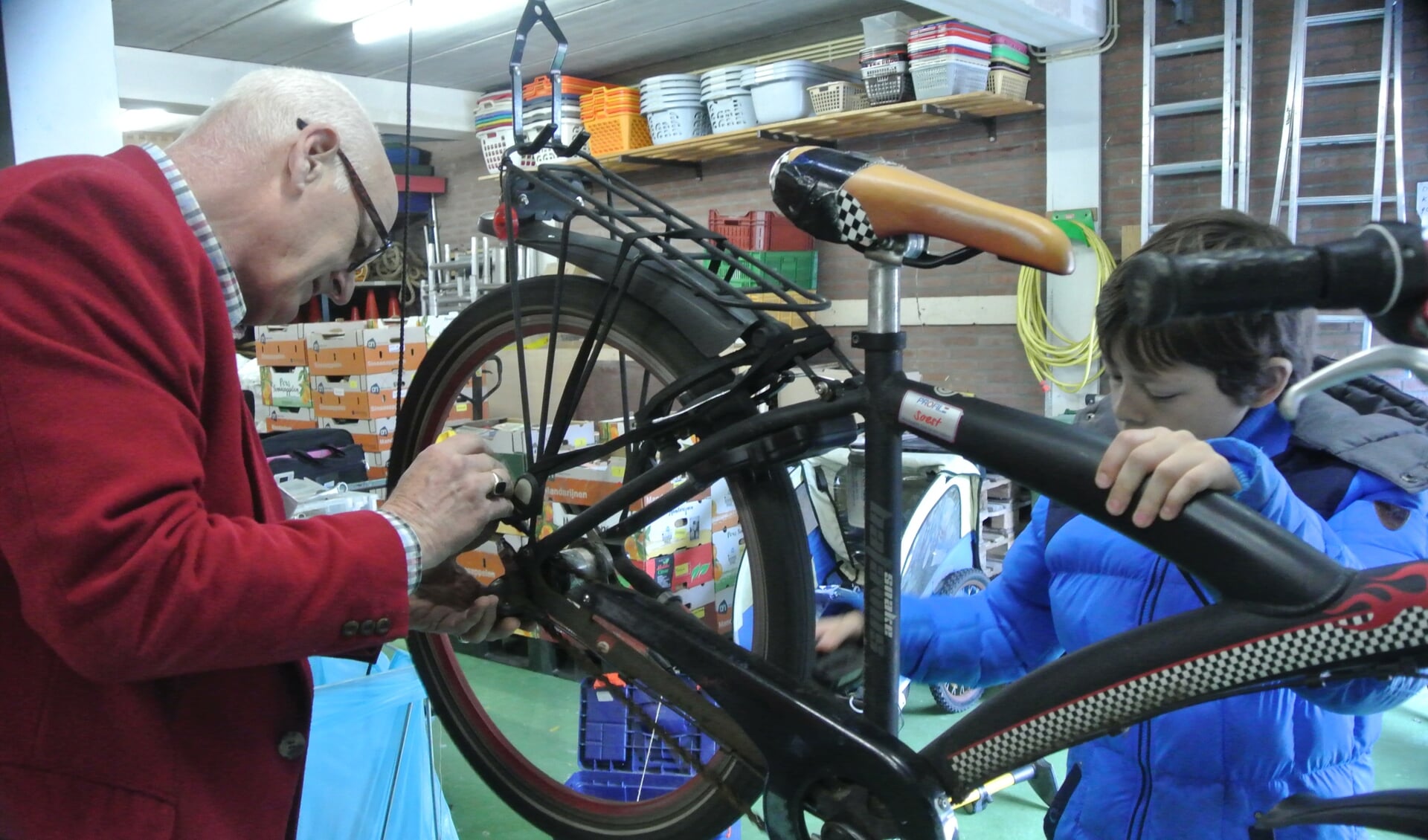 De elfjarige Leon Verwey uit Bilthoven kwam langs omdat zijn fietsketting steeds losging. Samen met reparateur Kees Stein (ook uit Bilthoven) legde hij de ketting strak. (foto Frans Poot)