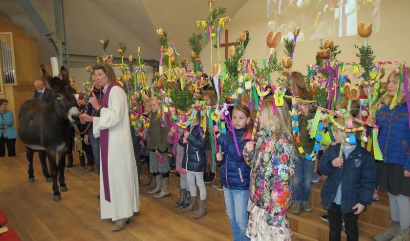Aandachtig luisteren de kinderen naar het verhaal van de dominee.