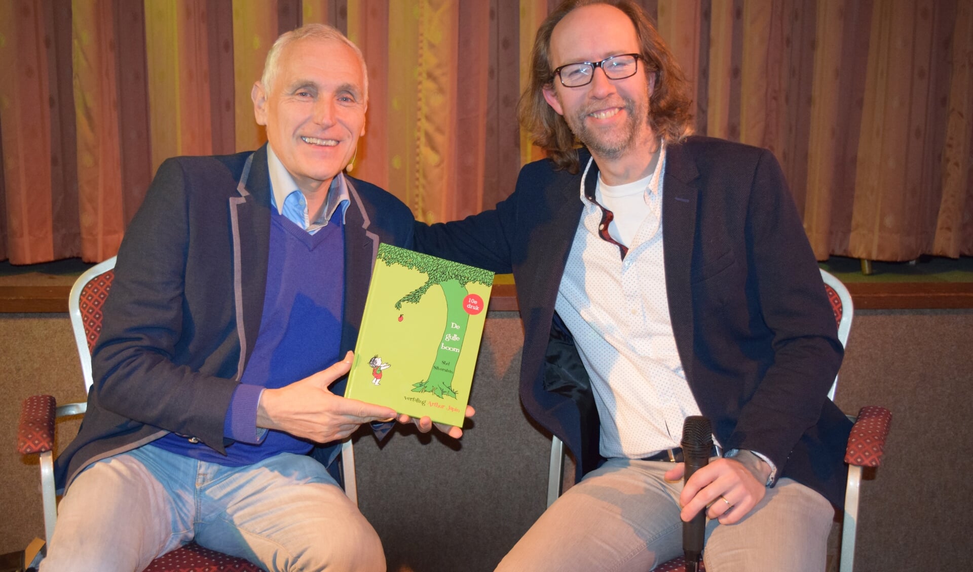 Peter van Dijk en Arthur Japin met het boek 'De Gulle Boom', het ontroerende verhaal over de vriendschap tussen een boom en een jongetje, klinkend vertaald door Arthur Japin (links).  