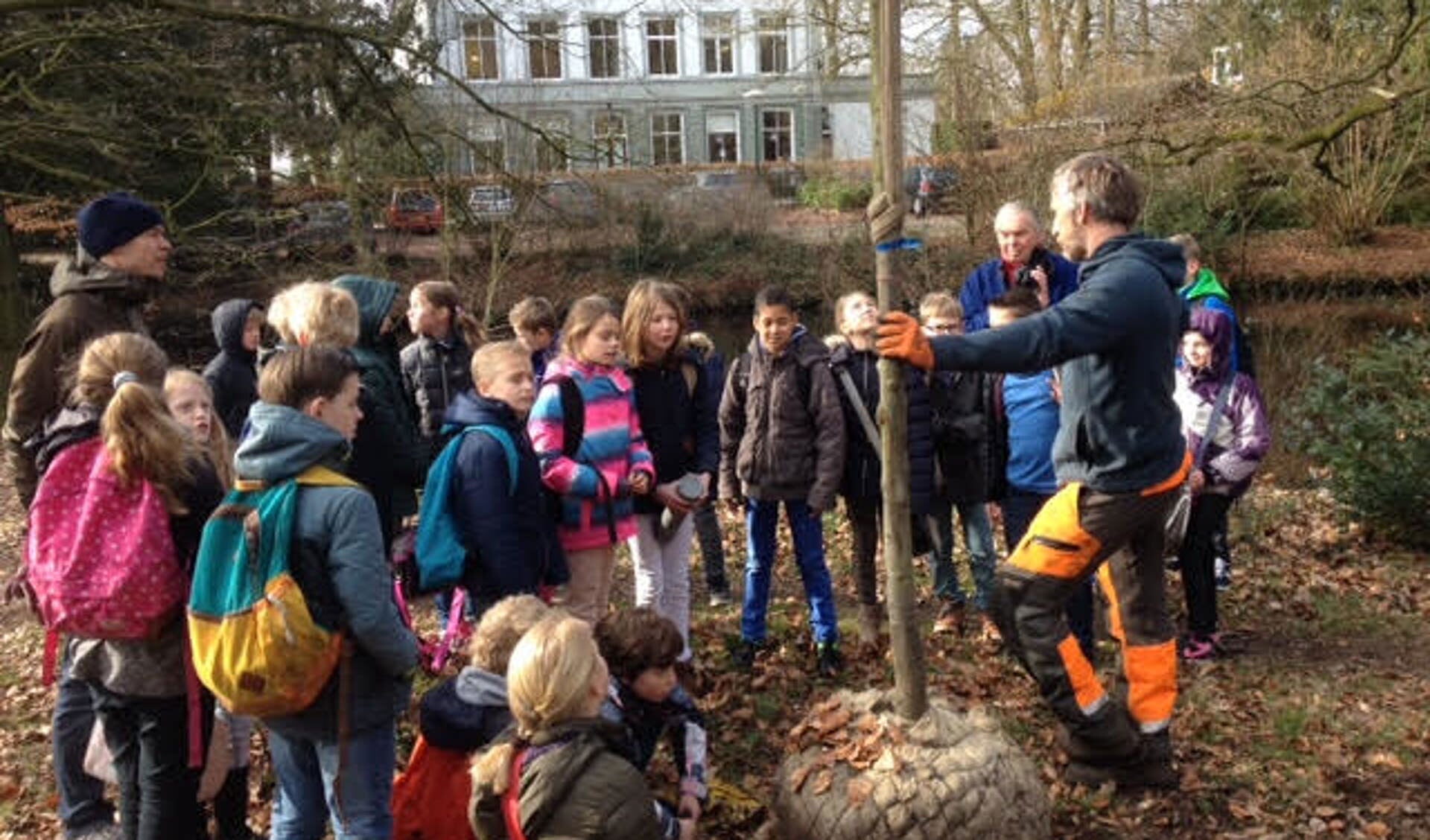 Leerlingen van de Nijepoort luisteren aandachtig voorafgaand aan het planten van de tamme kastanje.