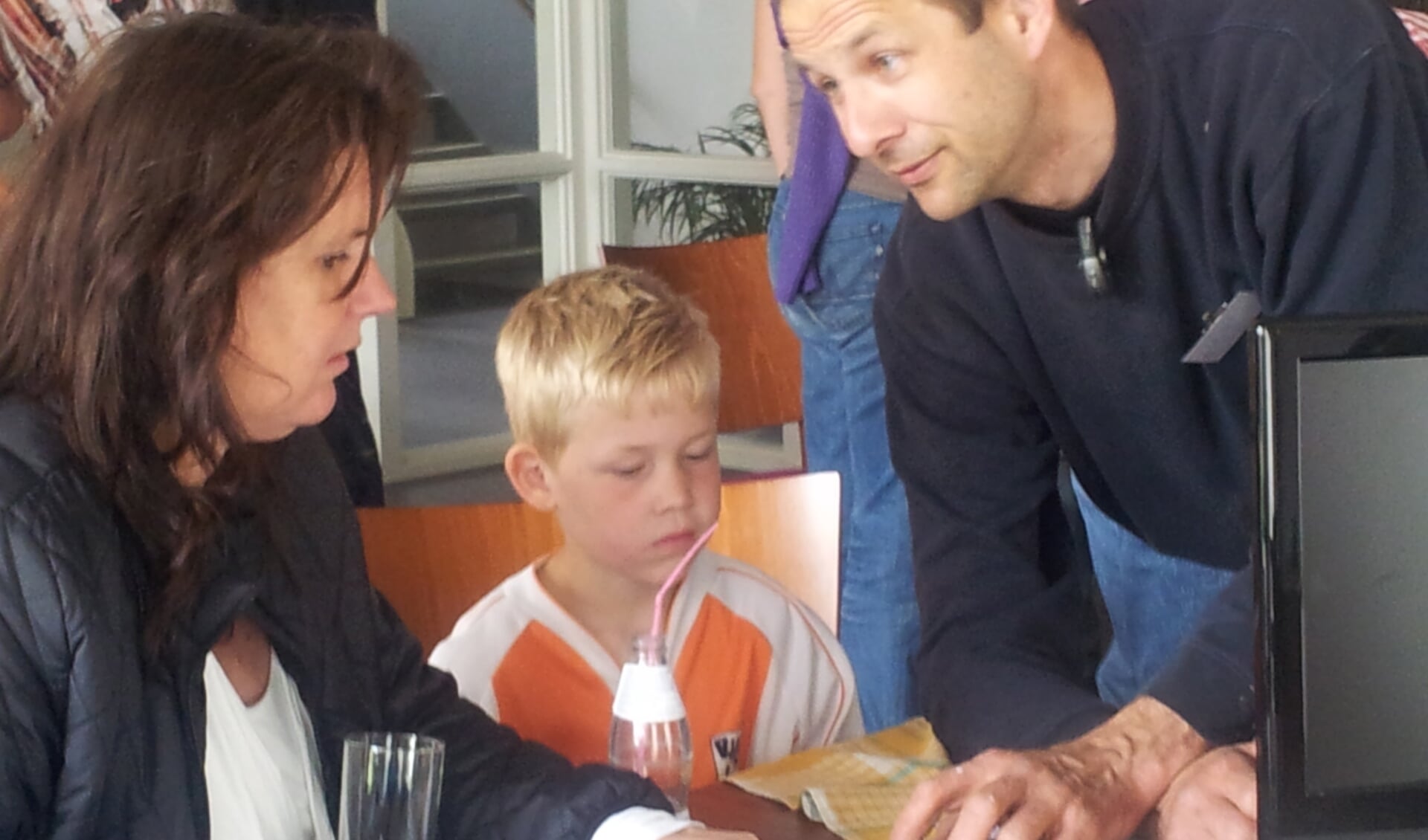 Annemiek en zoon Luc luisteren aandachtig naar de uitleg van reparateur Albert van Noort. (foto Hiemke Knijn)