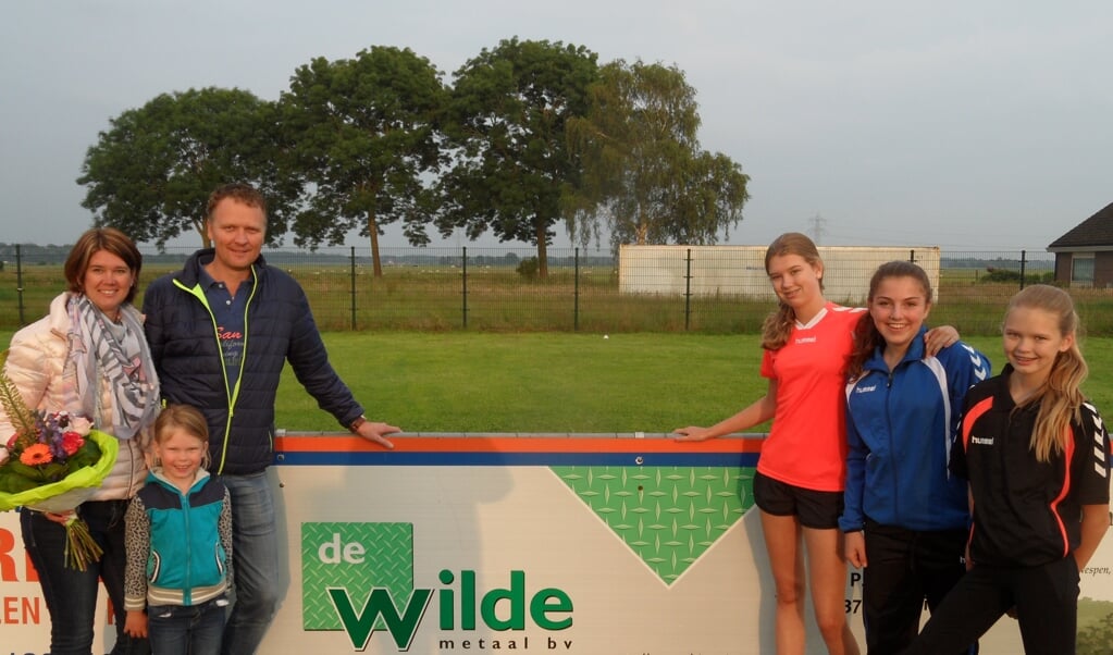 Corine en Gerben de Wilde met dochter Rozemarijn en spelers van DOS in het nieuwe trainingspak, wedstrijdshirt en inschietpolo.