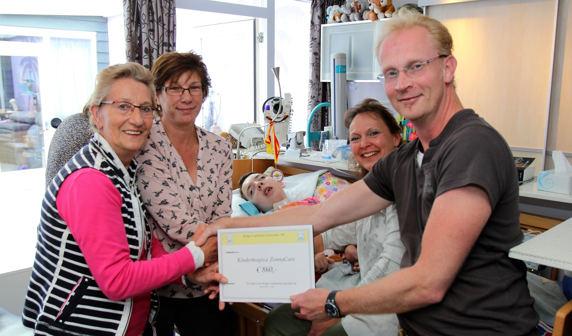 Lida Kuperus en Desirée Bosse van BCC'86 (l) overhandigen de cheque van 860 euro aan Annemieke Bernard en Matthijs van der Beek. [foto Reyn Schuurman].