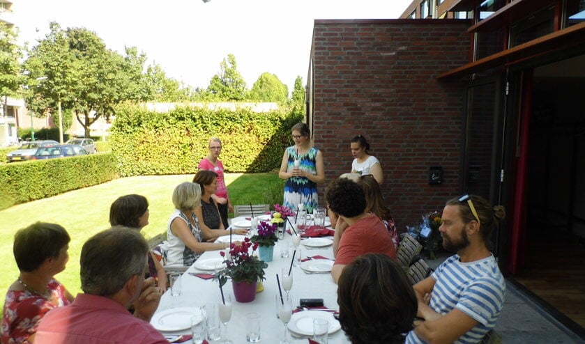 Christine Thomas (staand midden) heet de aanwezige welkom op de viering van het eenjarig bestaan van het Maatjesproject Samen Oplopen.