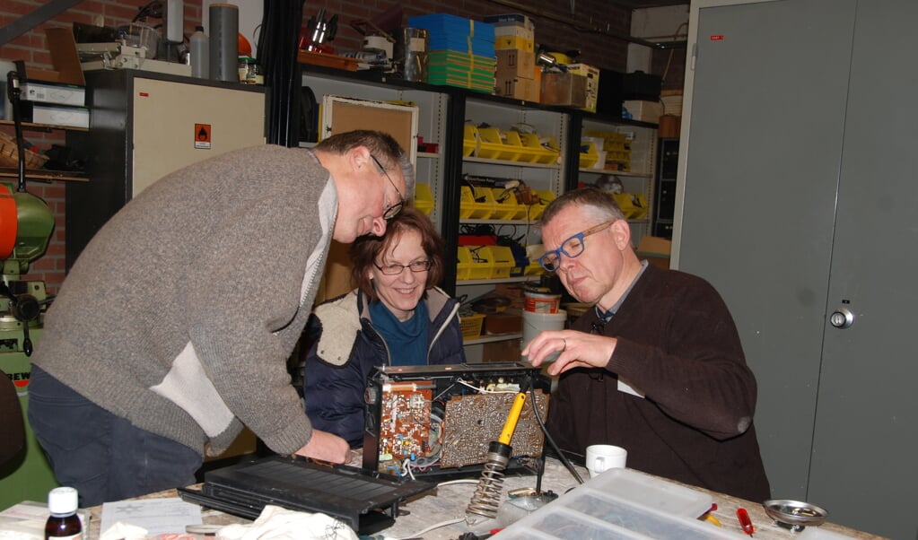 Reparateurs Peter en Roel in de weer met de reparatie van een cassettedeck.