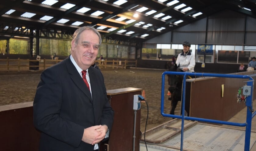 Burgemeester Verkerk naast de tillift bij stal van Brenk.