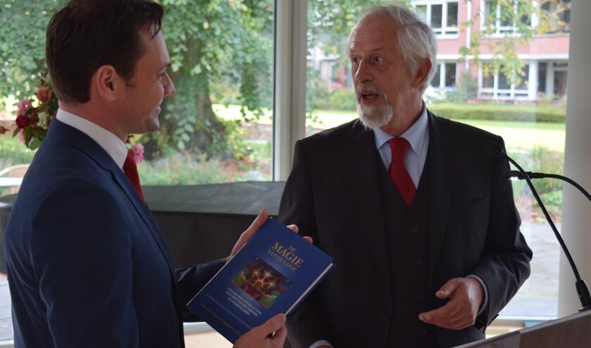 Grootmeester Gerrit van Eijk overhandigt het boek ‘Magie van de loge’ aan burgemeester Sjoerd Potters.