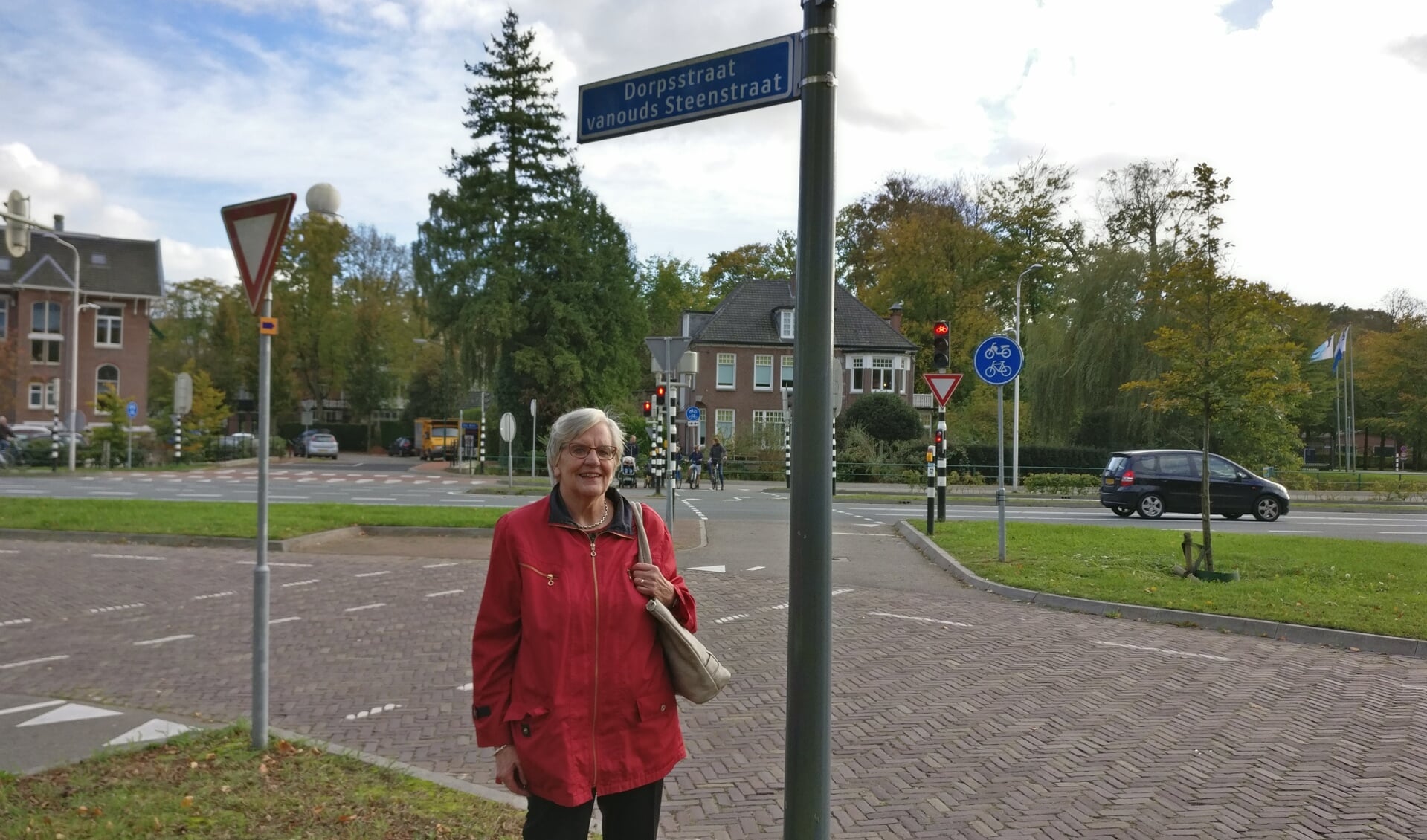  Lies Haan bij een bordje van de 'Dorpsstraat vanouds Steenstraat'op de hoek met de Bilthovenseweg.
