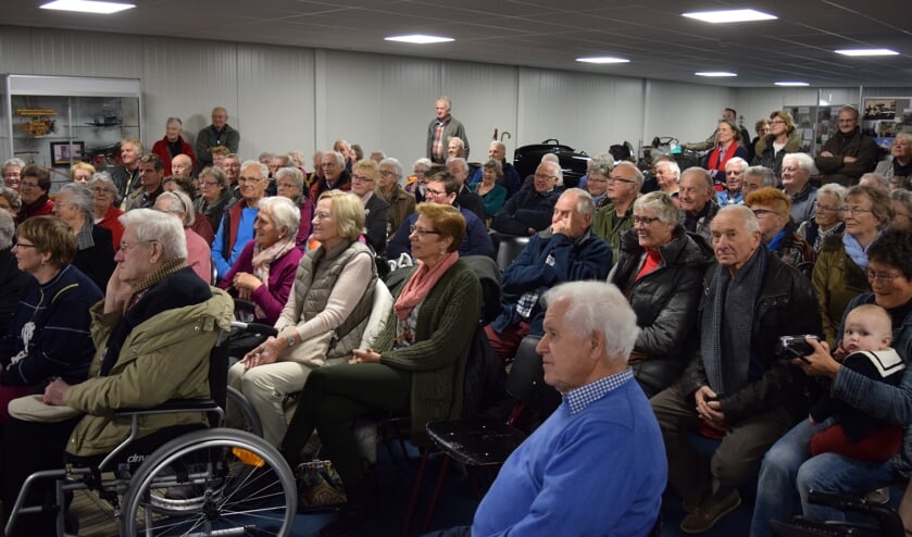 Een afgeladen zaal luistert naar de verhalen over vroeger